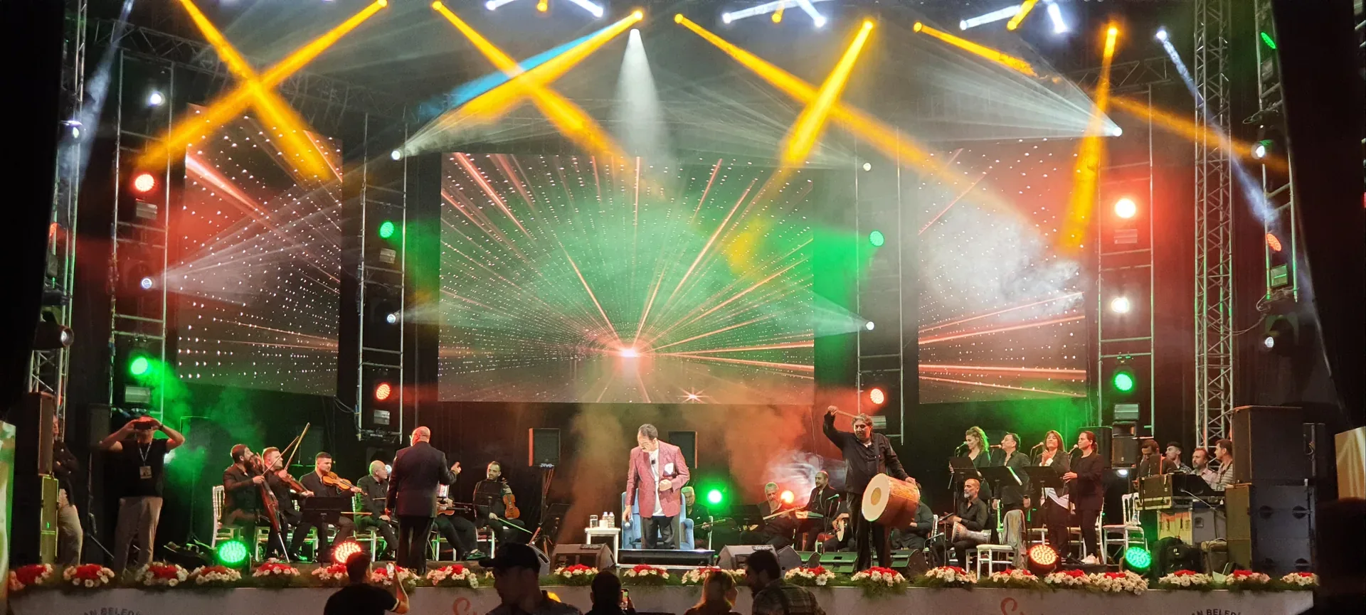 Sincan Yaz Konserleri’nde orkestra ve sanatçıların renkli hareketli ışıklar altında sahne aldığı an.